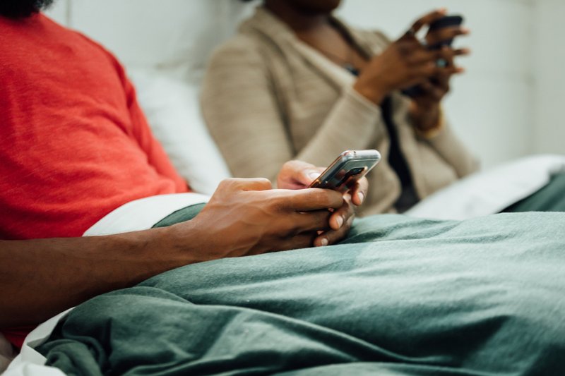 hands-hold-phone-in-bed