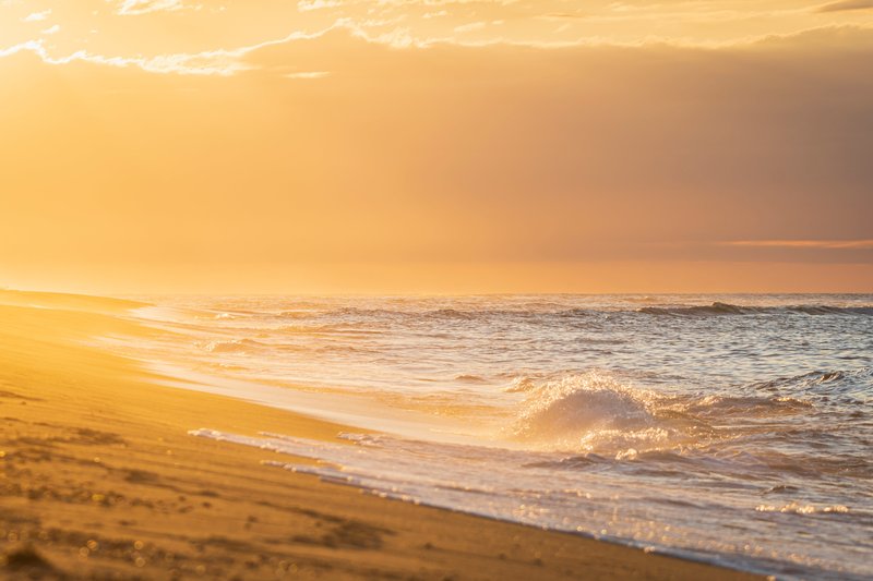 sunset-creates-orange-hue-along-the-beach